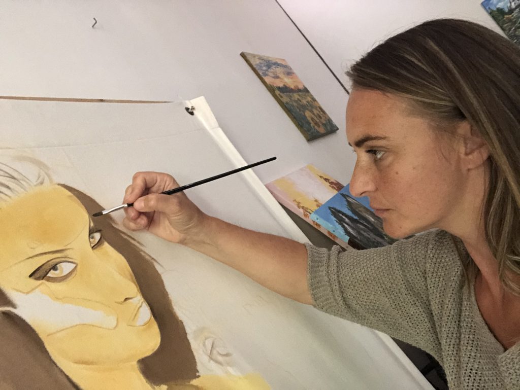 In the Presentation and Biography page - The artist representing Kate_Art, Katarzyna Boduch painting on an XXL Canvas for the 2020 Carpentras Butterfly Contest, a feline woman with her beehive